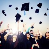 Graduates throwing mortar boards in the air